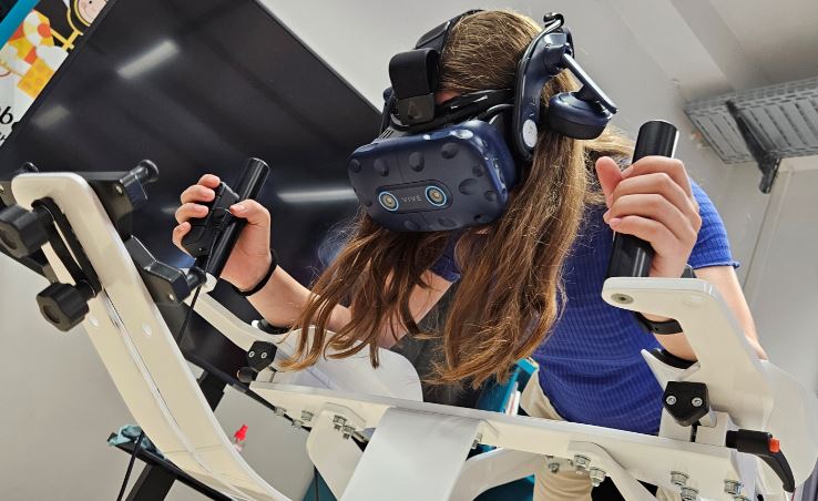 Mädchen bei Flugsimulation mit VR-Brille.