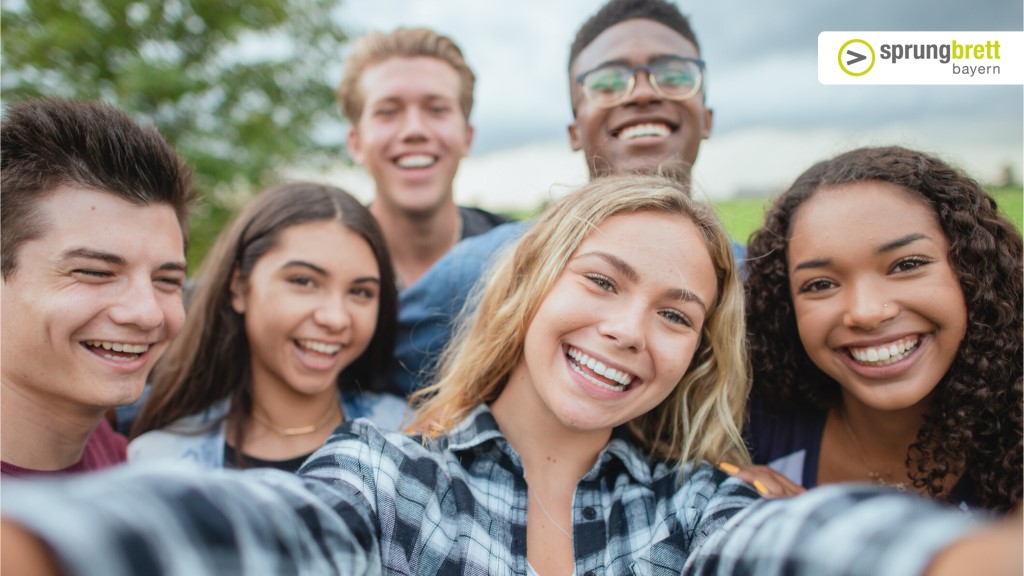 Sechs lächelnde Jugendliche posieren gemeinsam für ein Selfie.