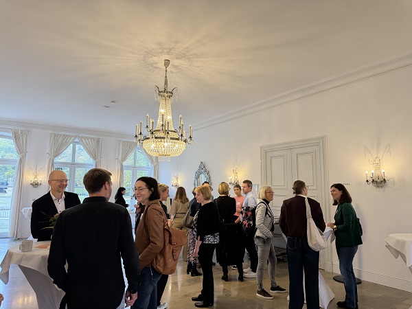 Besucher der Veranstaltung tauschen sich an Stehtischen aus.
